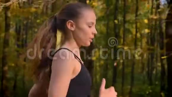 多莉拍摄特写肖像年轻苗条女孩穿连衣裙谁去秋季公园慢跑视频的预览图