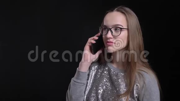 年轻迷人的时尚女性戴眼镜在电话中交谈的特写镜头视频的预览图