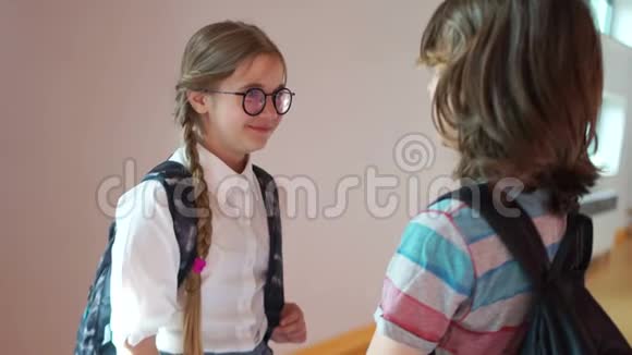 学校的爱男孩和女孩在学校走廊里说话男孩走近拥抱女孩他们视频的预览图