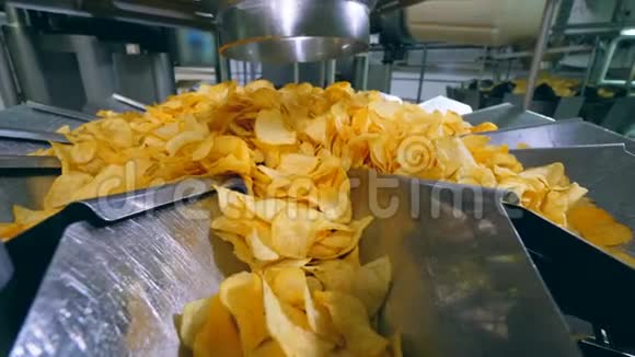 在一家食品厂的金属板上分类的黄色薯片视频的预览图