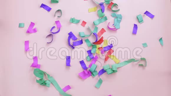 五颜六色的五彩纸屑落在粉红色的背景上视频的预览图