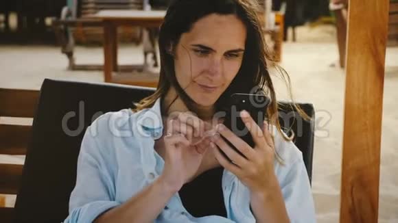 美丽的特写镜头快乐的年轻女商人使用智能手机娱乐应用程序微笑在躺椅上视频的预览图