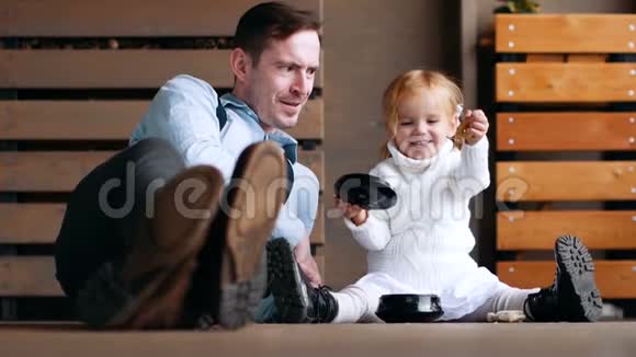 父亲和女儿坐在地板上玩童年记忆慢动作的复古时代家庭界限家庭视频的预览图