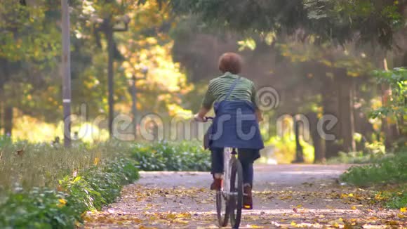 秋季公园骑自行车的高级女性慢动作视频视频的预览图
