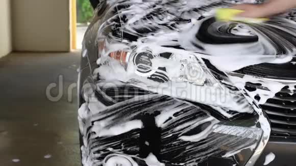 洗车用泡沫海绵把洗车大灯关上男性手视频的预览图
