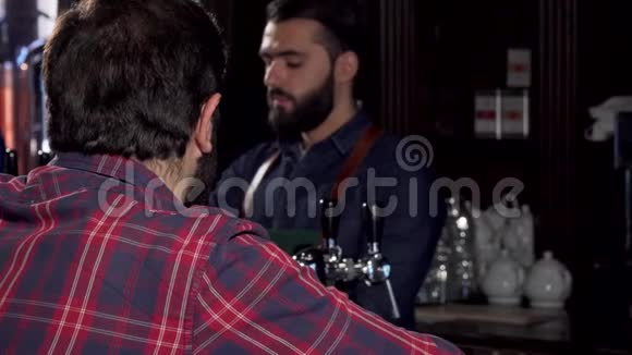 男顾客对着镜头微笑在酒吧喝着美味的啤酒视频的预览图