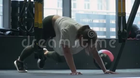 不可辨认的女人在健身馆里用两个重量做台阶美丽女人的健康生活方式身体视频的预览图