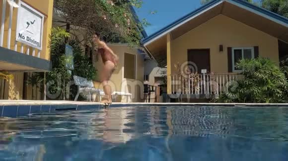 阳光明媚的一天年轻性感的女孩在豪华的游泳池里跳着后翻视频的预览图