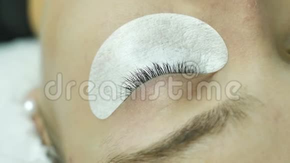 在美容院老板的眼皮上贴有底物的女性眼睛应用一种测量尺寸的模板视频的预览图