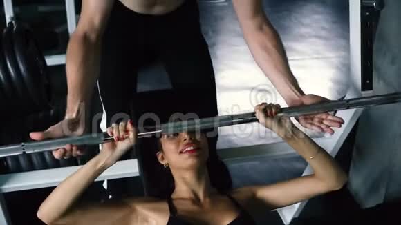 私人教练帮助女性在健身房做板凳练习视频的预览图