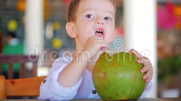 可爱的孩子喝椰子槽一根稻草特写概念孩子快乐童年夏天宝宝假期视频的预览图