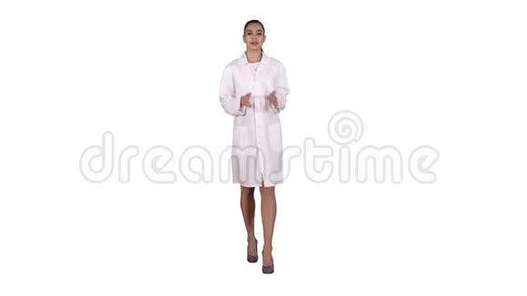 女医生在白色背景上行走时向摄像机解释和交谈视频的预览图