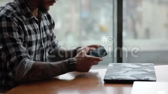 时尚帅气的自由职业者坐在咖啡馆里用笔记本电脑工作视频的预览图