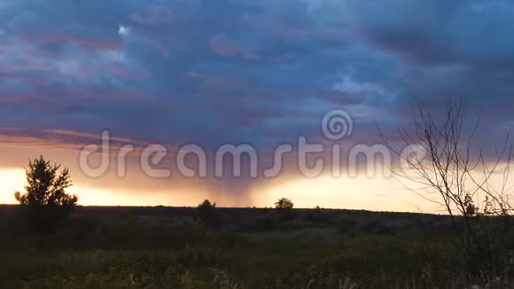 狂风暴雨的云层笼罩着傍晚的田野视频的预览图