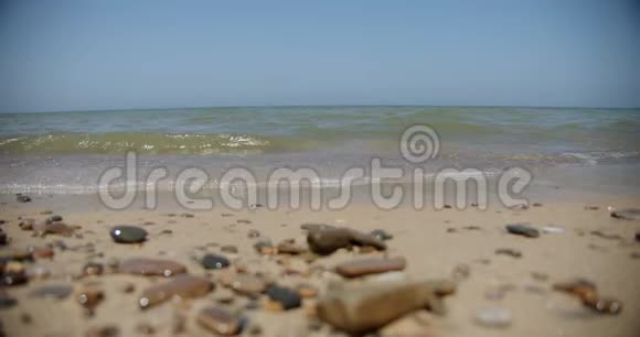 沙滩上柔软的海浪卵石特写慢动作4k视频的预览图