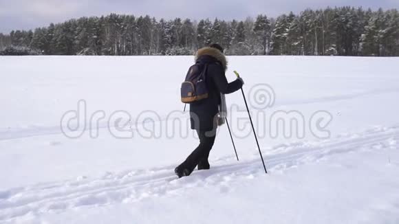 冬天在乡下背着背包滑雪的女人视频的预览图