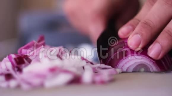 男人手在厨房的特写镜头里切紫色的洋葱视频的预览图