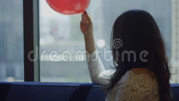 快乐的新娘坐在前面的气球和玫瑰花瓣视频的预览图