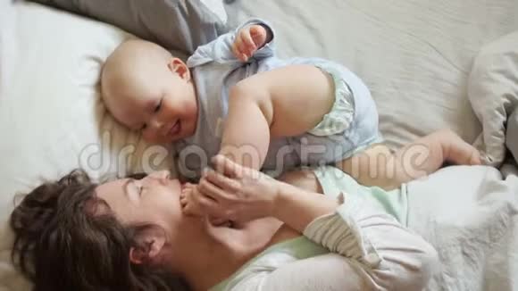 孩子的发展快乐妈妈玩弄躺在床上的宝宝的腿孩子们在数数一个女人视频的预览图