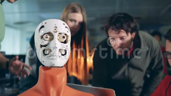 机器人移动它的脸而工程师与它一起工作关闭视频的预览图
