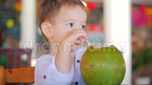 可爱的孩子喝椰子槽一根稻草特写概念孩子快乐童年夏天宝宝假期视频的预览图