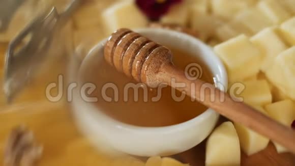 用不同的奶酪花和坚果放在木盘上的甜蜜视频的预览图