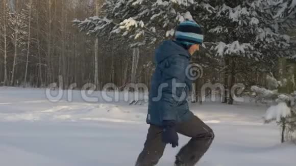 白人男孩走在雪地漂流冬季公园户外视频的预览图