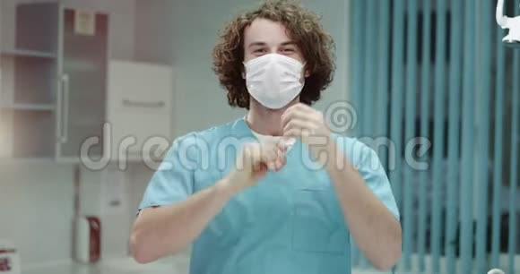年轻的牙医或医生在医院的特写镜头直视镜头摘下外科口罩和视频的预览图