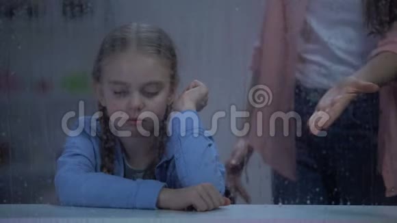 妈妈在雨窗后面对淘气的小女孩尖叫问题孩子视频的预览图