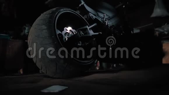 夜间车库里有大轮子的黑色摩托车幽灵自行车视频的预览图