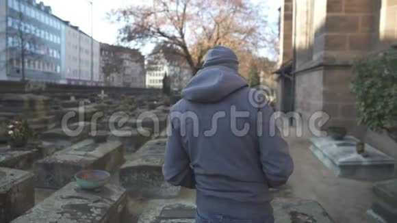 年轻人走在墓地之间的古代墓地历史的地点记忆视频的预览图