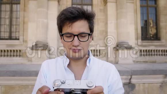 穿着白色衬衫的英俊男子为巴黎建筑拍照视频的预览图
