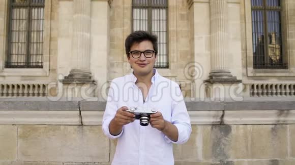 穿着白色衬衫的英俊男子为巴黎建筑拍照视频的预览图