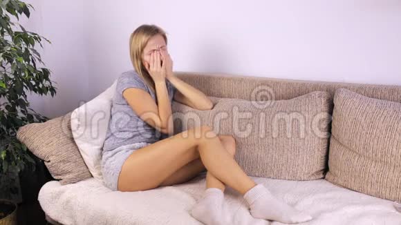 坐在沙发上的女孩用手揉着脸视频的预览图