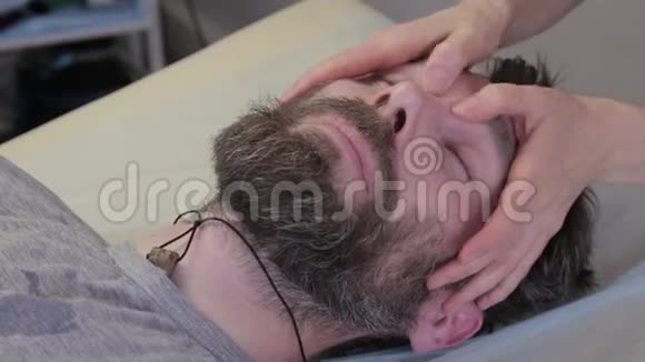 去做面部按摩美容程序预防皮肤老化躺在科斯莫医生的办公室里视频的预览图