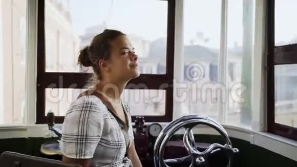 老式电车方向盘旁的积极女性视频的预览图