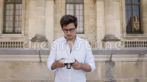 穿白色衬衫的英俊艺术家为巴黎建筑拍照视频的预览图