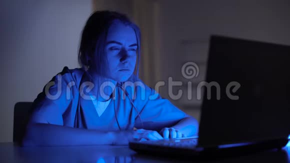 工作过度的女护士在黑暗的房间里坐在笔记本电脑前哭泣压力很大视频的预览图