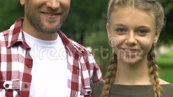 单身父亲和十几岁的女儿微笑着竖起大拇指家庭幸福视频的预览图
