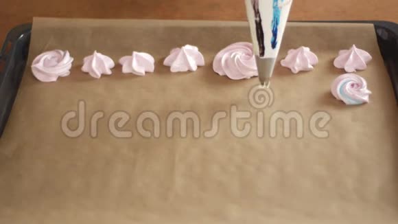 男人或女人的厨师用糕点套在面包托盘上挤出彩色糊状鲜奶油并配以奶油视频的预览图