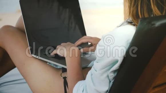 在异国海滨的笔记本电脑移动办公室工作的快乐成功女性自由职业者的后景特写视频的预览图