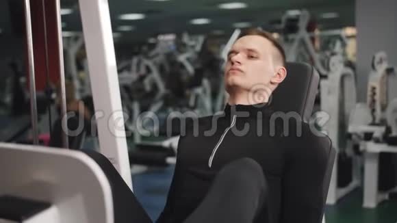男子在健身房做体重锻炼4k视频男性锻炼腿部大腿肌肉使用运动机锻炼身体视频的预览图