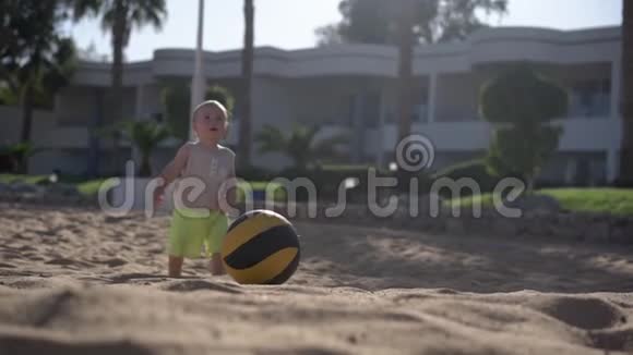 婴儿走在海滩上的球附近视频的预览图