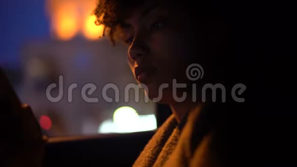 卷发女士坐在出租车上看手机晚上开车特写视频的预览图