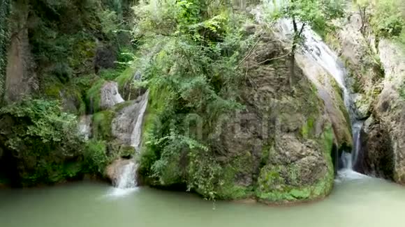 瀑布中间一块大石头的风景视频的预览图