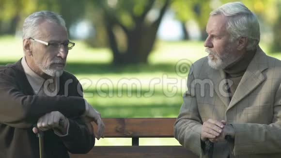 两个退休的男人在公园里看着迷人的女人朋友们玩得很开心视频的预览图