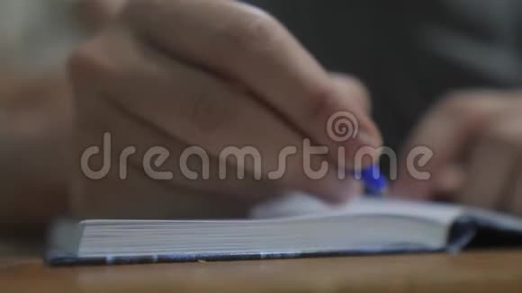 人在笔记本上写字男人的手写在记事本上理念商业教育生活方式男人做笔记视频的预览图
