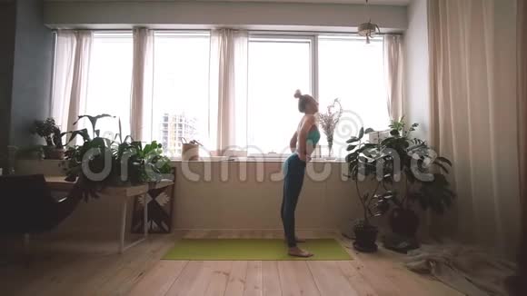 年轻的美女在家做瑜伽视频的预览图