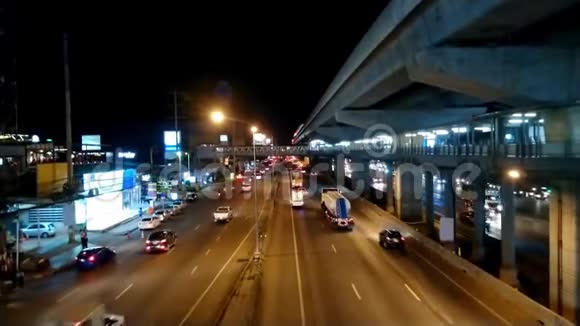 汽车在夜间行驶在道路上灯光照耀人们在人行道上行走视频的预览图