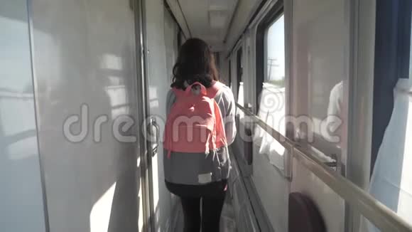 十几岁的女孩带着背包在火车车厢里散步旅游运输铁路概念小女孩走路视频的预览图